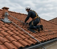 Operatore in quota assicurato a linea vita su copertura in tegole